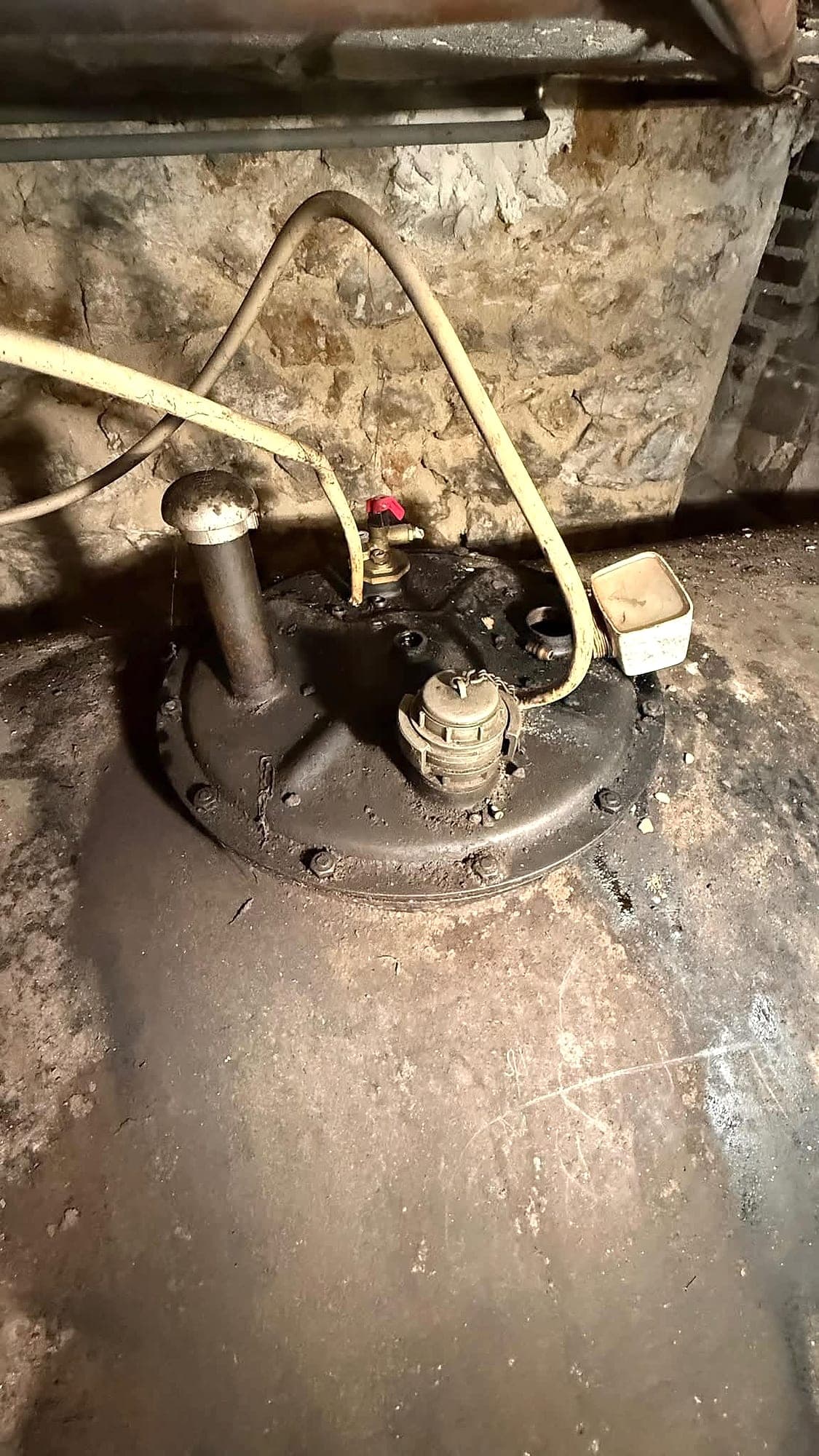 Dessus d'une cuve à fioul en cave avec son trou d'homme et ses raccords