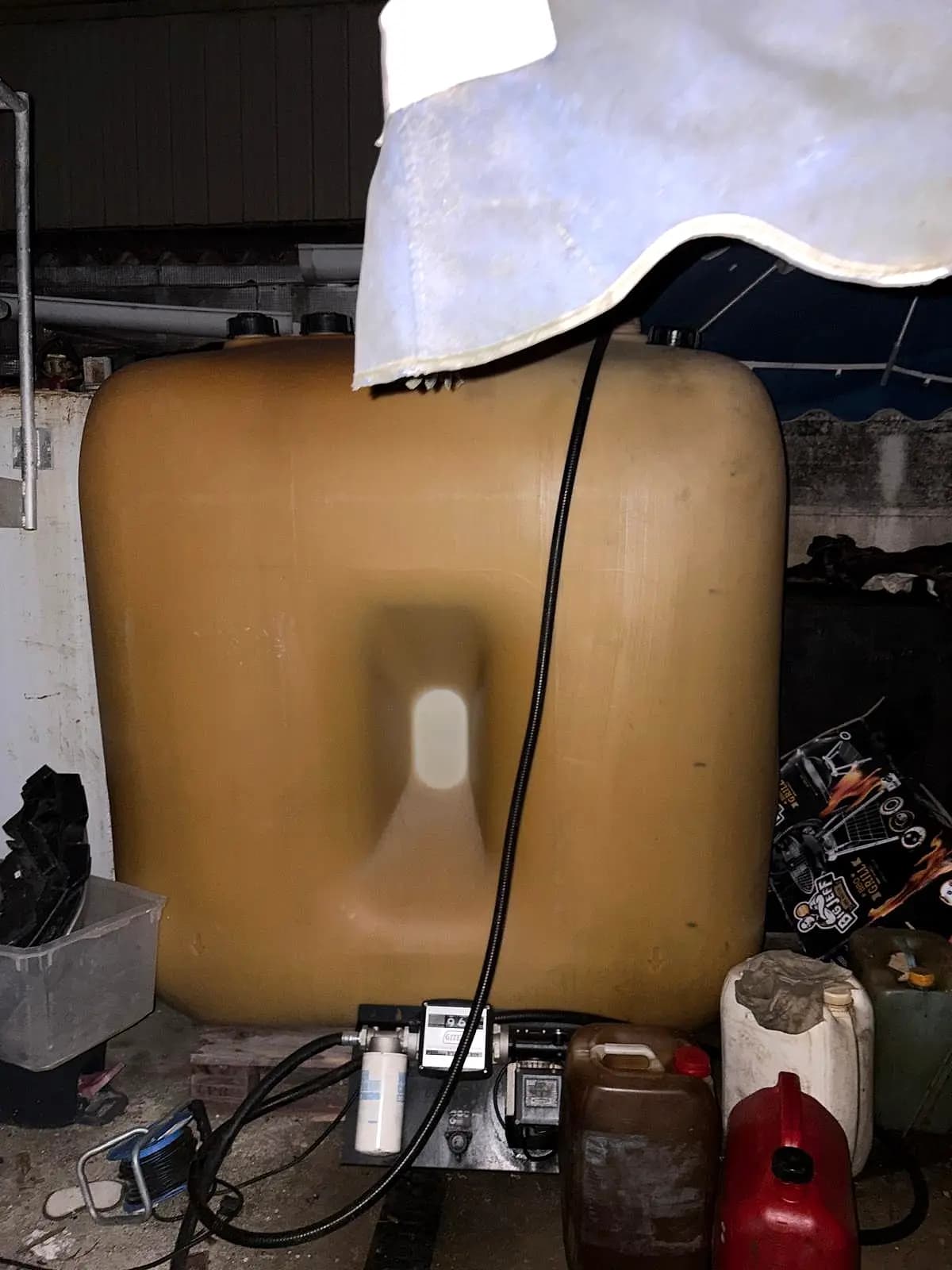 Cuve à fioul en plastique dans un garage, avec sa pompe de transfert et son compteur